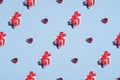 Pattern of gift boxes with red ribbon bow and red balls decorations on pastel blue background. Minimal style. Christmas or New Royalty Free Stock Photo