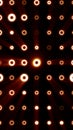 Pattern of glowing orange rings emitting radial light beams across a dark geometric grid Royalty Free Stock Photo