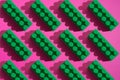 Pattern green plastic blocks of children`s constructor on a pink background Royalty Free Stock Photo