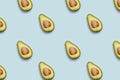 Pattern of half of avokado on blue background. Royalty Free Stock Photo