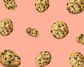 Pattern from homemade chocolate chips cookies flying in air on pink background. Baking kids birthday party sweets concept