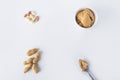 Pattern from Homemade Creamy peanut butter or paste in spoon and raw unpeeled groundnut on white background. Delicious breakfast