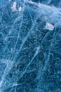 Pattern of lake ice and a small melted ice floe on the background.