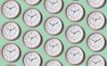 A pattern of a large number of large wall clocks on a light background Royalty Free Stock Photo