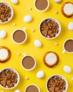Pattern made with bowls of oatmeal, coffee cups, buns with cottage cheese, eggs and cheese cubes on yellow background. Creative