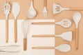 Pattern made from cooking utensil set. Silicone kitchen tools with wooden handle on beige background. Top view Flat lay Royalty Free Stock Photo