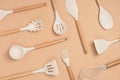 Pattern made from cooking utensil set. Silicone kitchen tools with wooden handle on beige background. Top view Flat lay Royalty Free Stock Photo