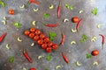 Pattern made of fresh vegetables and branch of cherry tomatoes on dark stone background. Royalty Free Stock Photo