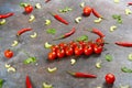 Pattern made of fresh vegetables and branch of cherry tomatoes on dark stone background. Royalty Free Stock Photo