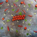 Pattern made of fresh vegetables and branch of cherry tomatoes on dark stone background. Royalty Free Stock Photo