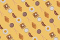 Pattern made with fried eggs, slices of crispy bacon, toast bread, croissant and glasses of milk on yellow background