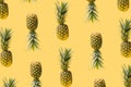 Pattern made of many modern, creative fresh exotic funky pineapples against illuminated yellow background. Levitating natural Royalty Free Stock Photo