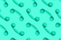 Pattern made from neo mint colored handset of a telephone on green mint background. Royalty Free Stock Photo