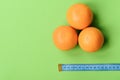 Pattern made of oranges near tape measure in cyan color