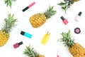 Pattern made of pineapple fruits and women cosmetics on white background. Flat lay, top view.