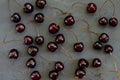 Pattern made of ripe red cherries with stalks lying on dark grey stone textred background. Freshly picked