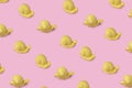 Pattern made from yellow snails on the pink background