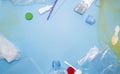 Pattern of many plastic bottles, caps, tubes, bags, tablets packaging arranged as a copy space frame on blue background. Saving th