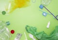 Pattern of many plastic bottles, caps, tubes, bags, tablets packaging arranged as a copy space frame on green background. Saving t