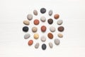 Pattern of natural multicolored pebbles on white wooden background.