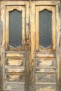 Pattern of old wooden double door with glass panes outside exposed to the weather. Close-up