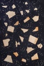 Pattern of pieces of wheat crispbreads with sesame seeds on dark grey shale background. Royalty Free Stock Photo