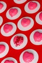 Pattern of pink mousse cakes with heart shaped mirror icing on red background Royalty Free Stock Photo