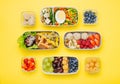 Pattern of plastic lunch boxes filled with healthy food on yellow background