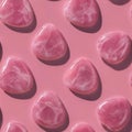 Pattern of polished pink stones with smooth surfaces arranged on a matching pink background casting soft shadows for an elegant Royalty Free Stock Photo