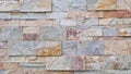 Pattern of rectangular natural stone tiles in mixed earthy tones forming a stacked wall texture Royalty Free Stock Photo