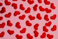 A pattern of red bright hearts on a pink