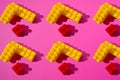 Pattern of red and yellow constructor details on a pink background