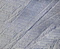 A pattern of relief footprints in the snow after cleaning the ski slope with a snowcat. Grunge knurled snow background ski