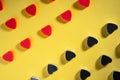 Pattern of rows of red and dark gray hearts on isolated yellow studio background. Crystals, glisten confetti Royalty Free Stock Photo