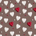 A pattern of scattered beads with shadows and red and white candy in the form of a heart on a gray background