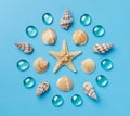 Pattern of seashells, starfish, and blue glass beads on a light blue background Royalty Free Stock Photo