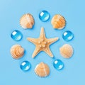 Pattern of seashells, starfish, and blue glass beads on a light blue background. Royalty Free Stock Photo