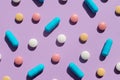 Pattern of several pills and tablets blue, pink, yellow and white colors on purple background. Creative tablets concept Royalty Free Stock Photo