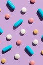 Pattern of several pills and tablets blue, pink, yellow and white colors on purple background. Creative tablets concept Royalty Free Stock Photo