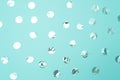 Pattern of shiny silver confetti on pastel turquoise paper background. Concept of holiday, birthday, blogging, beauty. Top view.