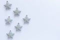 Pattern of silver glittery Christmas star ornaments on white background with copy space Royalty Free Stock Photo