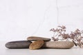 Pattern of smooth flat sea stones and dried flowers on the table copy space