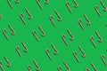 Pattern striped candy sticks on green background, lollipop, top view, flat lay