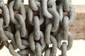 Pattern of thick rusty chain hang on wooden rail