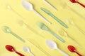 Pattern of a variety of plastic cutlery on a yellow background. Environmental pollution by plastic and microplastic