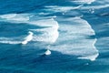 pattern of waves with spume at the beach