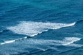 pattern of waves with spume at the beach