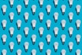 Pattern of white energy saving light bulbs on a blue background Royalty Free Stock Photo