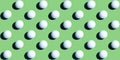 A pattern of white ping pong balls as spheres isolated on uniform green background. Banner size