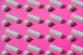 Pattern of white plastic blocks of children`s constructor on a pink background